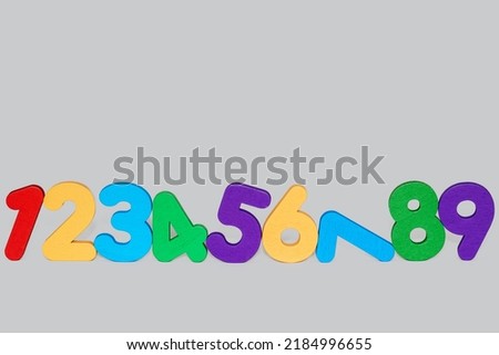 colorful numbers digits from 1 to 9 in a row isolated on grey background.learning number,back to school,kindergarten.space for text.mathematics,counting.wooden eco toys for preschool kids
