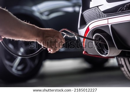 Measurement of exhaust emissions at the technical inspection station. A car repairman applies a probe to the exhaust. Royalty-Free Stock Photo #2185012227