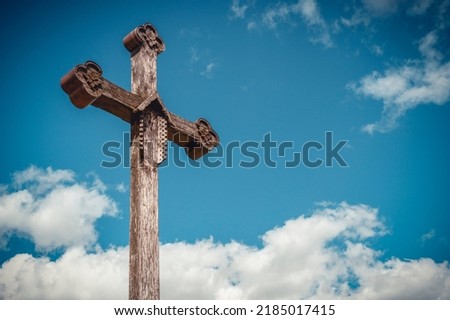 Old wooden cross with crucifixion against the background of the sky
