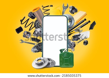 A various of new car spare parts and blank smartphone with white screen for your text or design on yellow background. Template for an application for the sale of spare parts for vehicles. Royalty-Free Stock Photo #2185035375