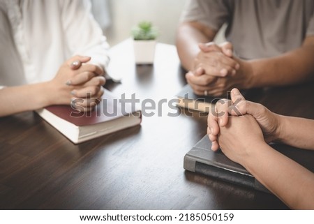 Asian Christian groups sitting within the Church Catholic prayed for blessings from God. A pale sun shone in a place of worship.Religious concepts. Royalty-Free Stock Photo #2185050159