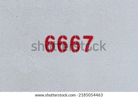 Red Number 6667 on the white wall. Spray paint.
