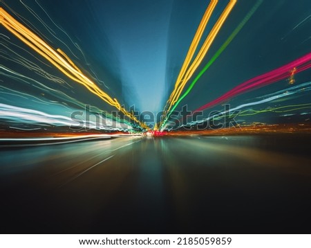 Beautiful image of colorful light trails from fast night drive on the highway, front view from the car window.