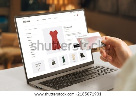 Shopping online with credit card concept. Modern e-commerce web page with woman clothes on laptop display Royalty-Free Stock Photo #2185071901