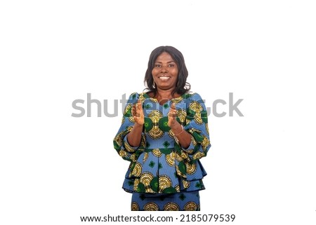 a mature businesswoman in traditional dress standing over white background applauding while smiling. Royalty-Free Stock Photo #2185079539