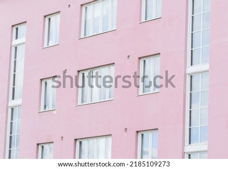 Full frame photo of a pink apartment complex or house wall with windows