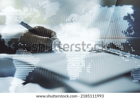 Double exposure of abstract digital world map and hand writing in notebook on background with laptop, research and strategy concept