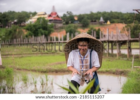 Mr. Guitar. Wearing a traditional costume and wearing a bamboo woven hat.