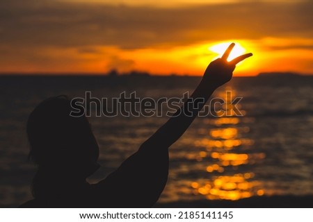 Female showing peace sign on nature bokeh blur sunset background. Copy space with the concept of happy love valentine's dream travel and freedom.