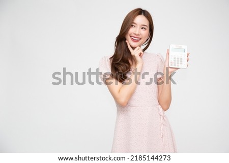 
Portrait of excited young Asian woman holding calculator and thinking isolated on white background, Business and financial concept