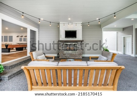 Patio with teak furniture television barbeque fireplace and dangling light bulbs