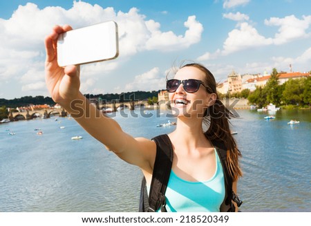 Summer, holidays, vacation and happiness concept - Pretty young girl taking selfie with smart phone