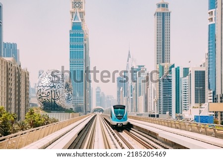 Monorail Subway train rides among glass skyscrapers in Dubai. Traffic on street in Dubai. Museum of the Future in Dubai. Cityscape skyline. Urban background. Royalty-Free Stock Photo #2185205469
