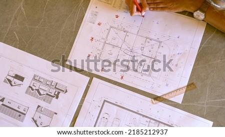 TOP DOWN: Young female using feng shui chart for energy flow analysis evaluation. Young woman making a feng shui plan for balanced home, good harmony and efficient house interior design arrangement. Royalty-Free Stock Photo #2185212937