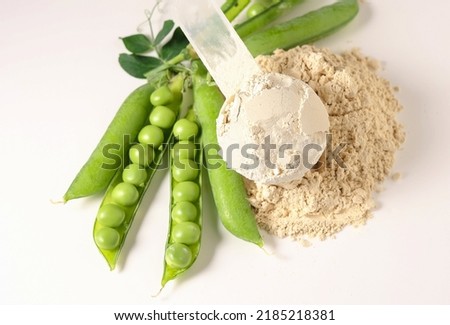 Plant base protein Pea Protein Powder in plastic scoop with fresh green Peas seeds on white Background, isolated copy space.  Royalty-Free Stock Photo #2185218381