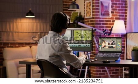 Male videographer working with color gradient software to edit video for professional film montage on computer. Editing movie footage with sound and visual effects to create multimedia content.