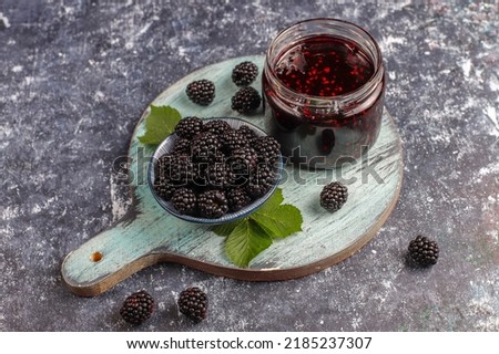 Jar of blackberry jam on marble background from top view, Fresh homemade blackberry jam in glass, Sweet homemade blackberry jam in small glass jar on wooden background, with fresh berries copy space. Royalty-Free Stock Photo #2185237307