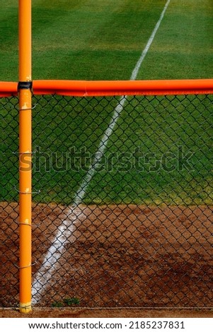 Outfield fence and green grass on baseball field diamond for competition and playing sports