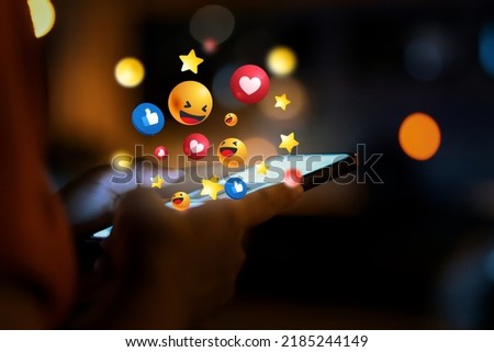 Woman using smartphone at night and social 3D graphics icon on screen with beautiful bokeh. girl's hand using a smartphone social icons on smartphone screen Royalty-Free Stock Photo #2185244149