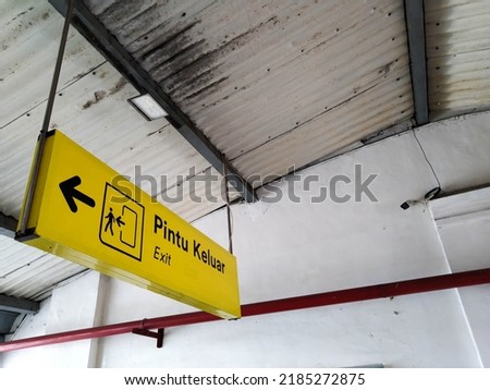 Yellow notice board that says "Exit" at the station