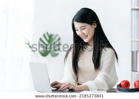 Education online learning or self study concept. young asian girl do researching and finding from books and internet online.