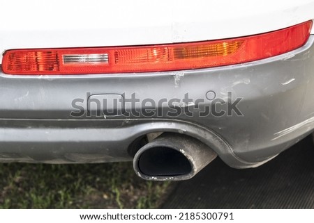 Scratched rear bumper on a white car, cracks and bumper repair close-up. White car with a broken and cracked bumper Royalty-Free Stock Photo #2185300791