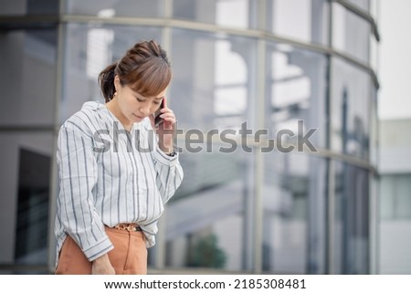 Business woman talking on smartphone (troubled) Royalty-Free Stock Photo #2185308481
