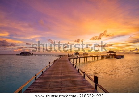 Amazing beach landscape. Beautiful Maldives sunset seascape view. Horizon colorful sea sky clouds, over water villa pier pathway. Tranquil island lagoon, tourism travel background. Exotic vacation Royalty-Free Stock Photo #2185321923