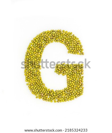 Capital letter G made from mung beans. Green mung bean font. Alphabet made from green gram . White background. Dry green maash seeds.