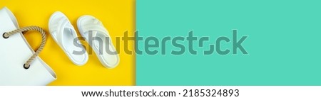 Women's summer white slippers and a white rubber bag with brown handles on a yellow blue background. Slippers. Banner for insertion into site. Place for text cope space. Horizontal image