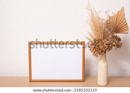 Mock up empty wooden frame mockup, dried leaf and grass in vases on white background, interior, home design. Art concept. copy space