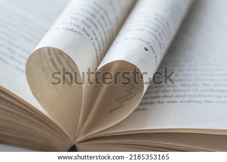 Love of books, reading. An open book with folded pages of books in the shape of a heart. Knowledge Day, Teacher's Day. Library. Reading books. Royalty-Free Stock Photo #2185353165