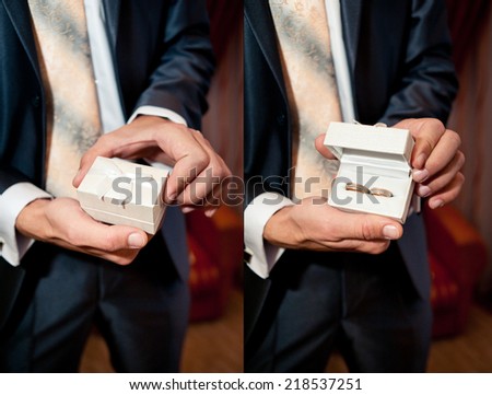 groom holding wedding rings