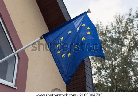 Flying EU flag on the building wall EU flag fluttering in the wind close-up