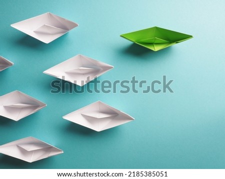 New ideas, creativity and various innovative solutions or leadership, ecology concept, paper boats on a bluish background