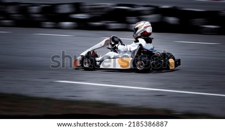 Go kart racing field, racer wearing safety uniform on competition tournament.  Royalty-Free Stock Photo #2185386887
