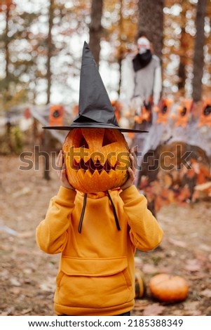 Small boy with halloween pumpkin in black witch hat. Little boy having fun, celebrating halloween concept
