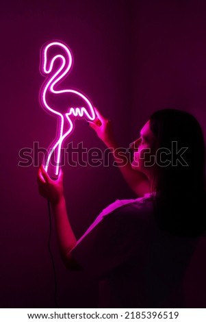 Beautiful girl with neon signs. Pink neon flamingo. Trendy style.  Neon sign. Custom neon. Home decor. 