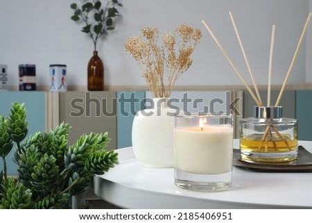 luxury lighting aromatic scented candle is on white metal table with ceramic vase and reed diffuser to creat relax ambient in the bedroom with background of nice bedroom and curtain on Valentine day Royalty-Free Stock Photo #2185406951