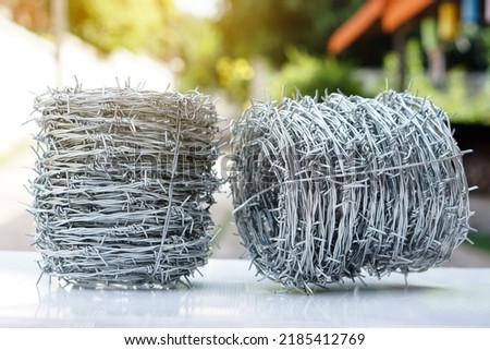 Rolls of barbed wire. Barbed wire is used for make fences , secure property and make border to show the territory of  area.                            Royalty-Free Stock Photo #2185412769