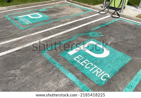 The logo sign of an electrical vehicle parking spot inside a shopping center. Eco electric cars industry.