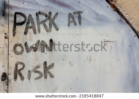 park at own risk written on steel door 