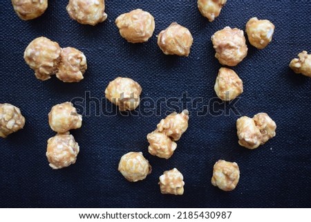 Caramel popcorn snacks emptied out from container bag cup and mess after home alone party sleepover celebrations and movie night and party fun birthday invitation presentation backdrop background
