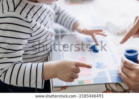 Finger painting. Portrait of cute little boy painting with fingers at home. Close-up of child's hand in colorful paints. Early education concept. Sensory play. Development of fine motor skills. Royalty-Free Stock Photo #2185446491