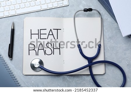 Notebook with words Heat Rash, stethoscope, pen and keyboard on light grey marble table, flat lay
