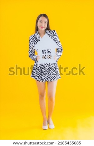 Portrait beautiful young asian woman show home or house sign on yellow isolated background