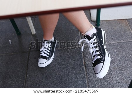 casual trendy sneakers shoes on the legs close up photo. High quality photo