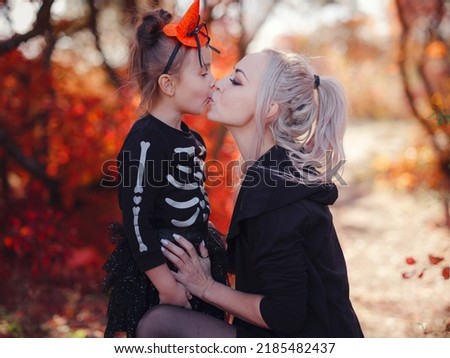 Mother and her child girl playing together. goes trick or treating. Little witch, Kids with jack-o-lantern. Children with candy bucket in fall forest. Happy Halloween.