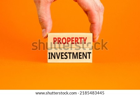 Property investment symbol. Concept words Property investment on wooden blocks on a beautiful orange table orange background. Businessman hand. Business Property investment concept. Copy space.