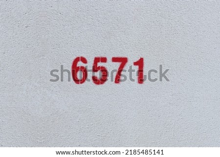 Red Number 6571 on the white wall. Spray paint.
